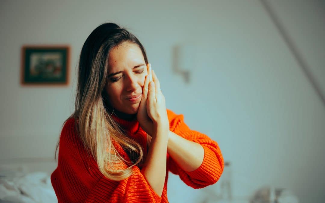 Woman feeling extreme dental pain from a common toothache